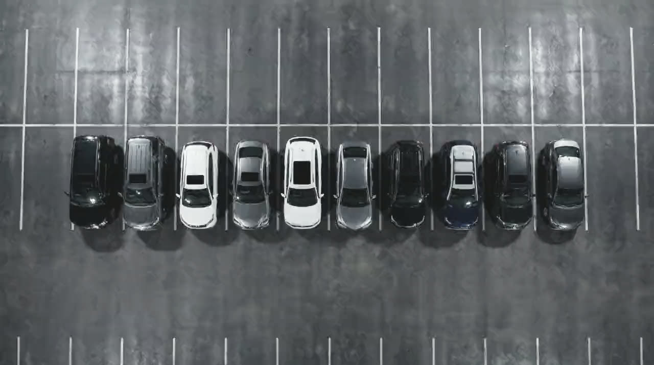The same cars from directly overhead in flat daylight, lined up one per bay with the painted lines running between them.
